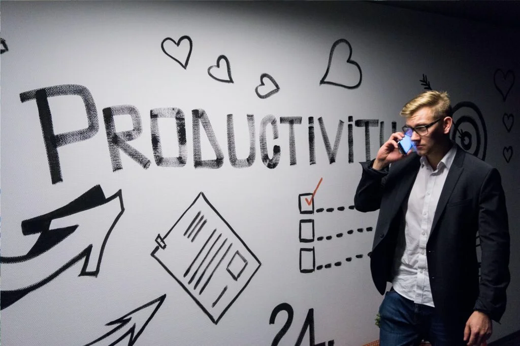 A professional working on a computer, using various AI productivity tools to manage tasks, meetings, and emails.